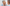 Photo of a white woman with short grey hair looking at her skin in the mirror