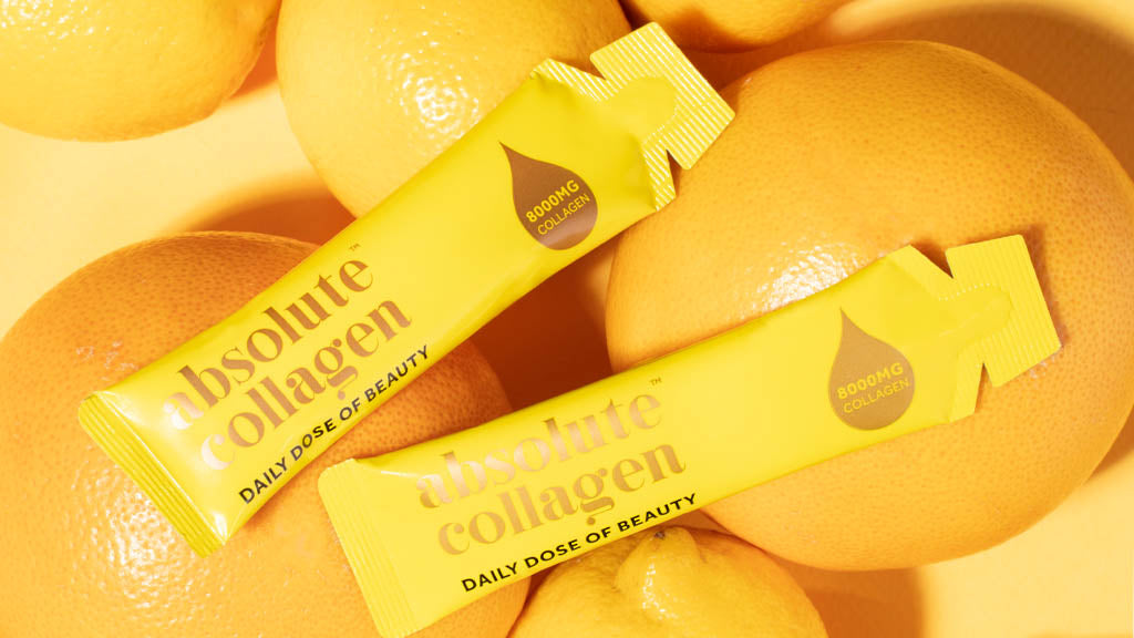 Photo showing two Absolute Collagen sachets lying on a pile of oranges