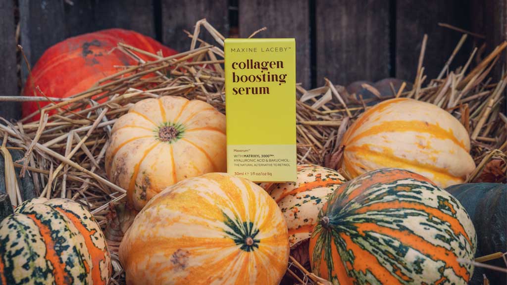 Photo of a box of Maxerum serum standing on top of a pile of pumpkins with straw in the background